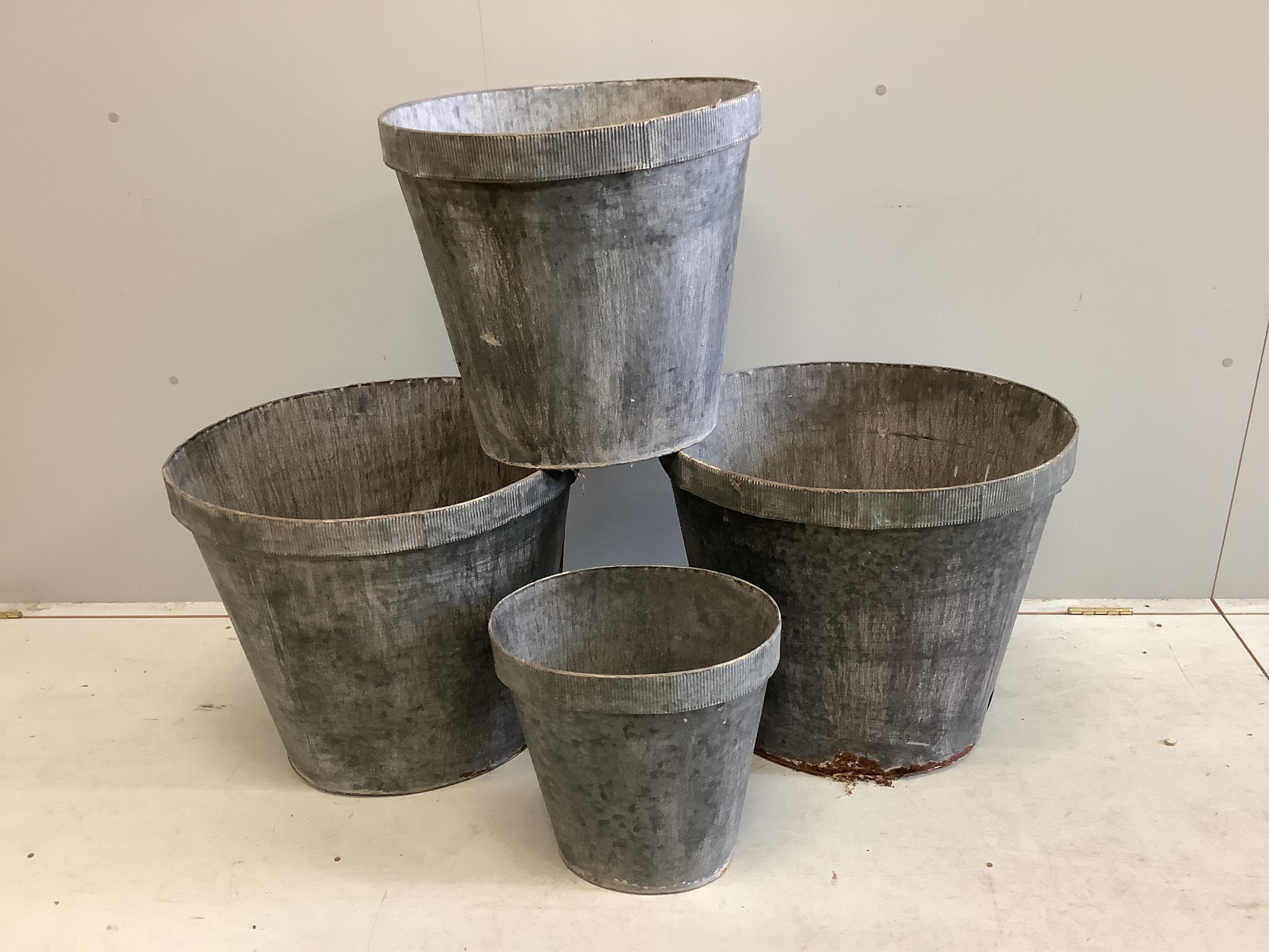 A graduated set of four oval zinc containers, largest width 56cm, height 50cm. Condition - poor to fair